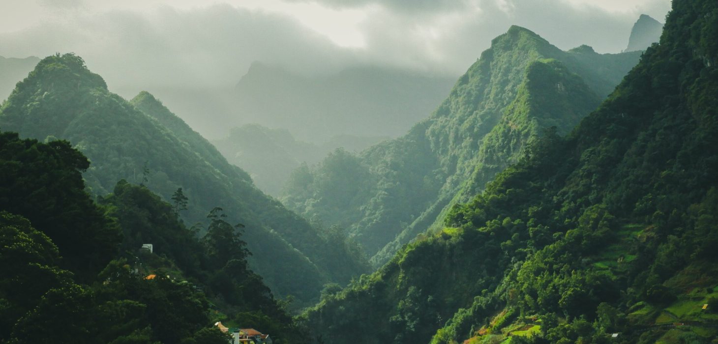 A mesmerizing scenery of green  mountains with cloudy sky background